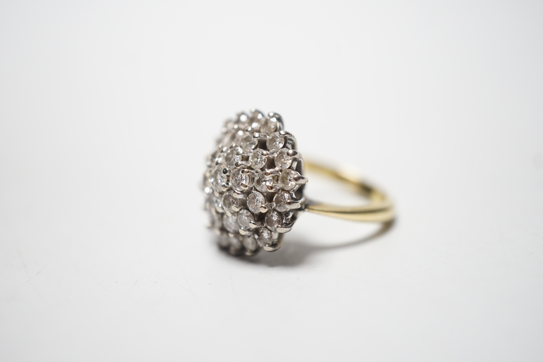 A modern 18ct and diamond set circular cluster ring, size I/J, gross 7.9 grams.